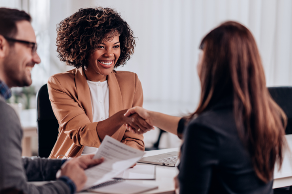 Beobachtende geben junger Teilnehmerin bei einem AC freundlich die Hand